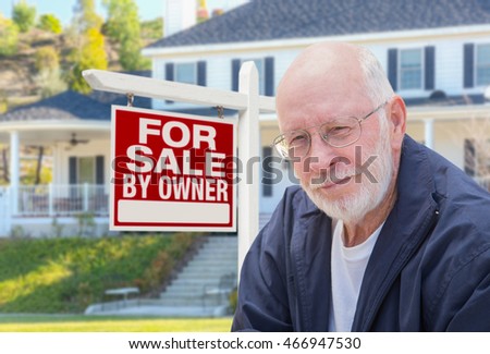 Senior Adult Man in Front of Home For Sale By Owner Real Estate Sign and Beautiful House.