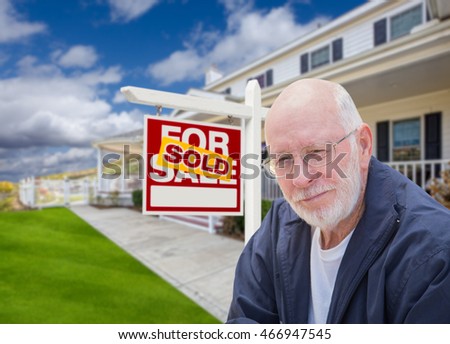 Senior Adult Man in Front of Sold Home For Sale Real Estate Sign and Beautiful House.