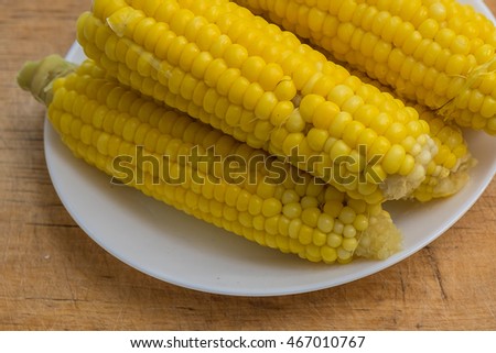 Boiled corn on a white plate in the kitchen. Close up