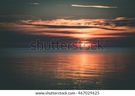 Beautiful sunset over the sea with clouds and reflections - vintage film effect