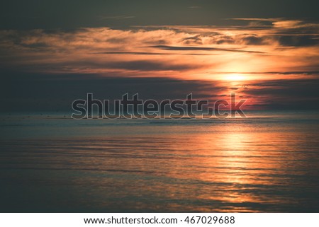 Beautiful sunset over the sea with clouds and reflections - vintage film effect