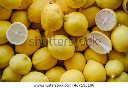 Colorful Display Of Lemons In Market. Lemon background. Lot of bright yellow lemons in supermarket