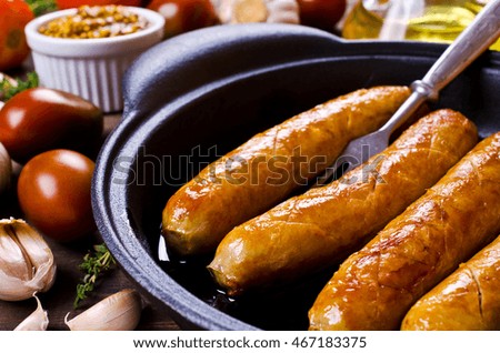 Homemade grilled sausages with vegetables on a wooden background. Selective focus.