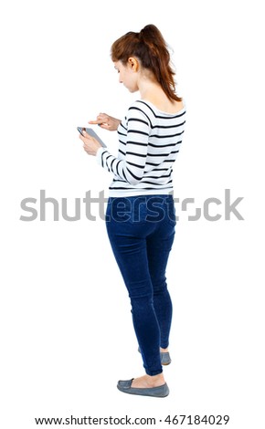 back view of standing young beautiful  woman using a mobile phone or tablet computer. girl  watching. Rear view people collection.  backside view of person.  Isolated over white background. Girl in a