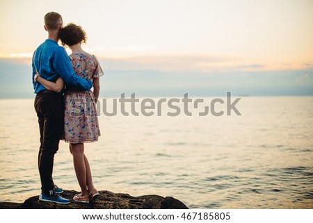 A look from behind on the woman leaning to man's shoulder standing on the stone Royalty-Free Stock Photo #467185805