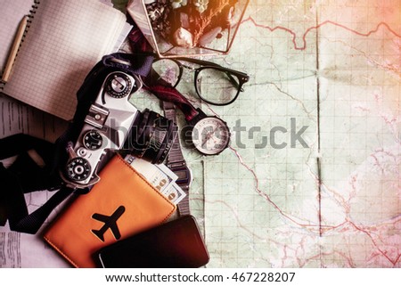 wanderlust and adventure concept, compass camera phone passport money notebook  on map, top view, space for text, vintage toned image Royalty-Free Stock Photo #467228207