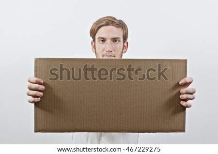 Young Adult Man in White Shirt Holding a Big Cardboard Inscription