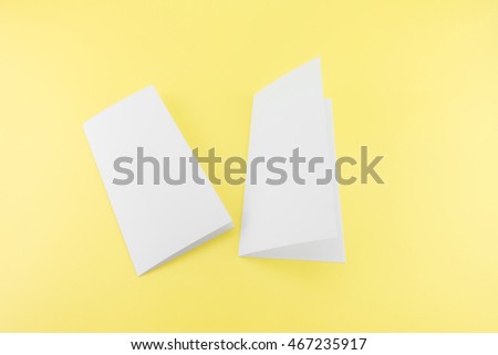 Blank white template paper on yellow background with soft shadows. Ready for your design.