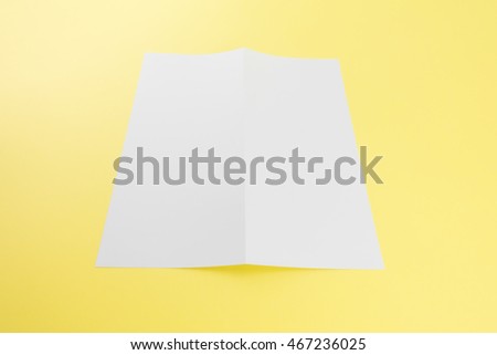 Blank white template paper on yellow background with soft shadows. Ready for your design.