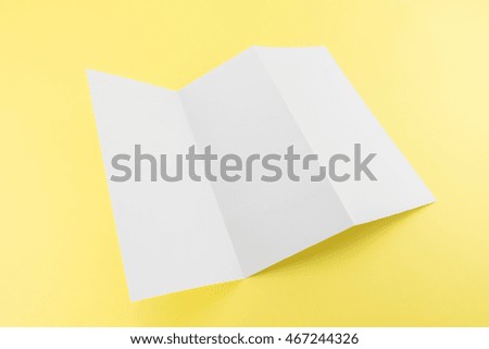 Blank Trifold white template paper on yellow background with soft shadows. Ready for your design.