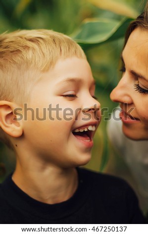 Portrait of a happy mother and her son  outdoor.  Series of a mother and son outdoor portrait in a park. Portrait of smiling mother and son. Family photo. The concept of a happy family.
