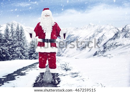 Santa Claus in a red suit on a winter road in the mountains