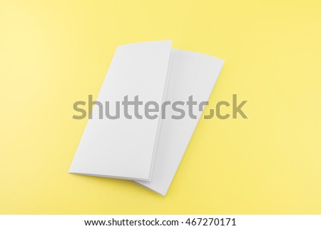 Blank Trifold white template paper on yellow background with soft shadows. Ready for your design.