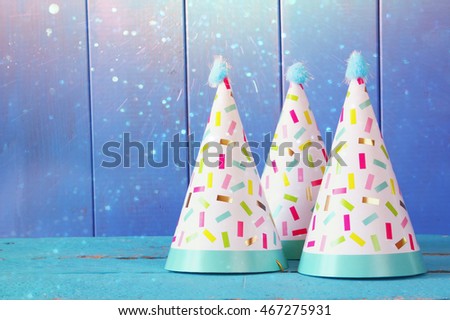 Party hat on wooden table. Glitter overlay.