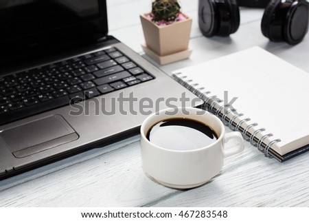 Blank notebook with pencil and cup coffee,laptop on table background copy space / selective focus