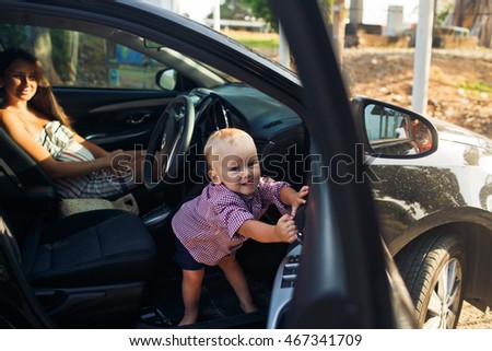 The small child sits in car