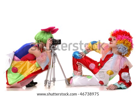 Two clown-girls in wigs and fancy costumes taking photos