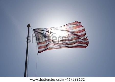 American Flag with Sun in Background