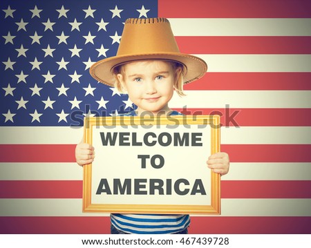 Little Funny girl in striped shirt with blackboard. Text welcome to America. On background of American flag.