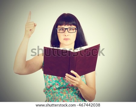 The teacher with glasses holding a book in his hands. Showing thumbs up.