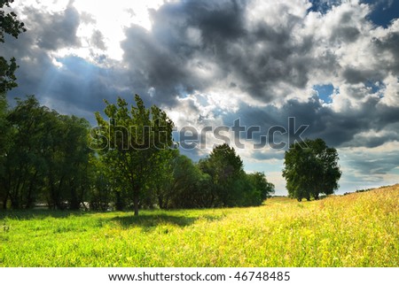 Landscape with the bright sun and the storm sky