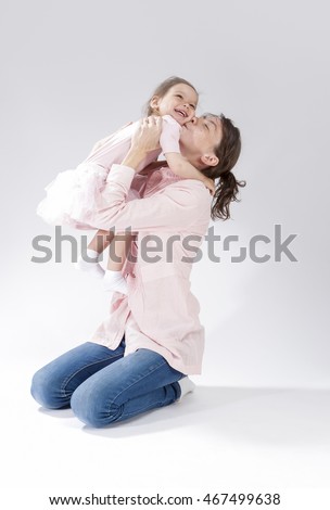 Love and Relationships Concepts. Portrait of Young Mother Kissing Her Child with Positive Expression. Against White. Vertical Image