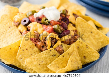 Beef nachos with  jalapeno, olives, tomato, beans cheddar cheese and sour cream