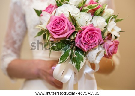 Bride's bouquet in her hands. Beautiful flowers roses bouquet - wedding accessory. Flowers for the holiday.