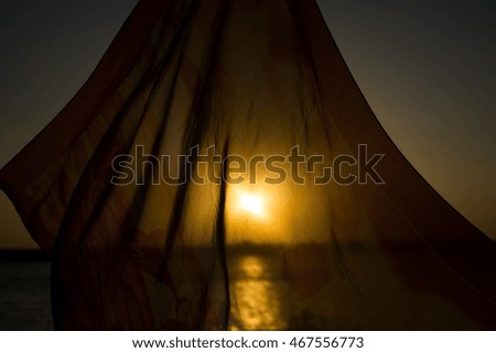 Beautiful blazing sunset landscape at black sea and orange sky above it with awesome sun golden reflection on calm waves as a background. Amazing summer sunset view on the beach. Russian nature, Sochi