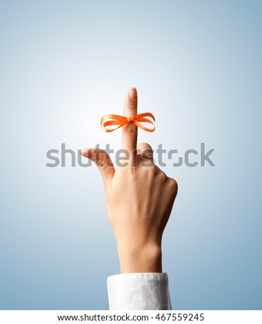Reminder. Red bow on index finger Royalty-Free Stock Photo #467559245