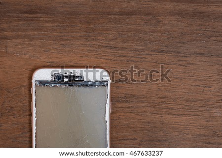 Close up of crash mobile phone on wooden table.