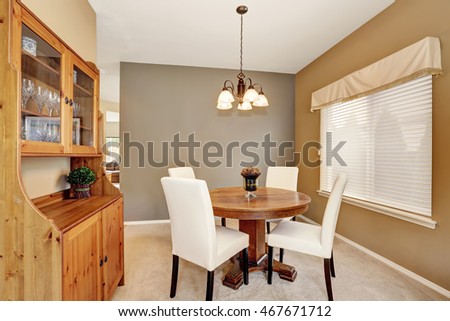 Cozy dining room with white chairs and vintage round table and kitchen cupboard. Northwest, USA