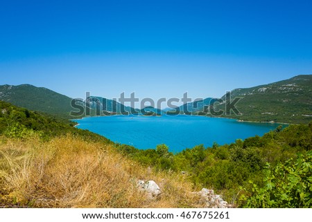 Croatia Europe. Beautiful nature and landscape photo of Adriatic. Warm nice summer day with clear blue sky and water. Green trees and grass. Lovely outdoors image with mountains at horizon. Calm happy