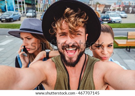 Friends taking selfie and one talking on the phone. Summertime
