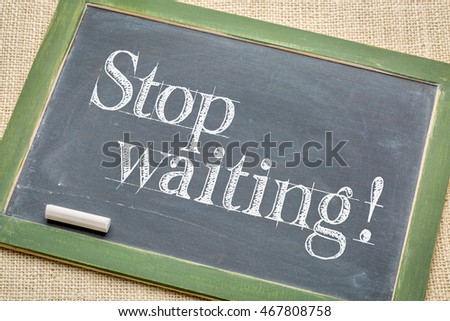 stop waiting advice  on a  vintage slate blackboard with a white chalk against burlap canvas
