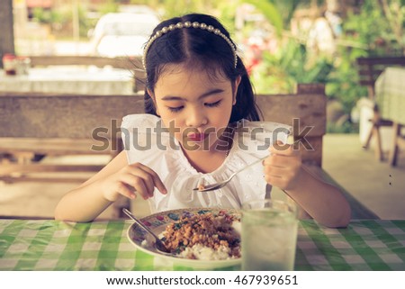Asian kid girl Eating basil pork in Thailand.