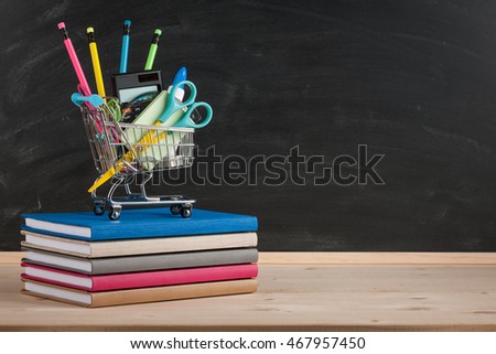 Back to school concept with school supplies on blackboard background