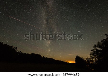 Beautiful milky way galaxy on a night sky and silhouette of tree with cloud, Long exposure photograph.with grain