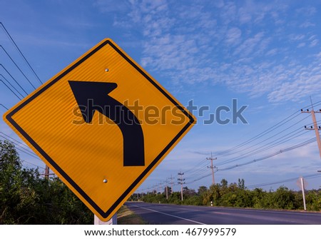 street sign curve and blue sky.