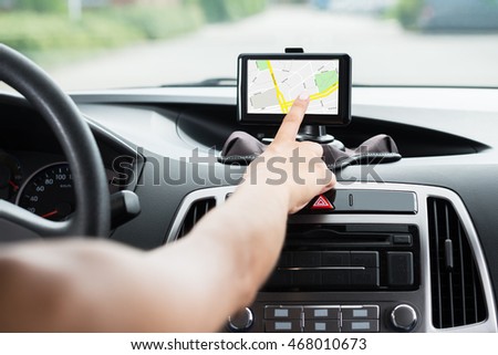 Close-up Of Female's Hand Using GPS Navigation Inside Car Royalty-Free Stock Photo #468010673