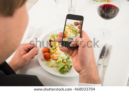 Close-up Of Man Taking Picture Of Food With Mobile Phone