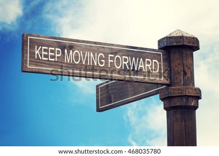 Keep moving forward on old wooden sign.