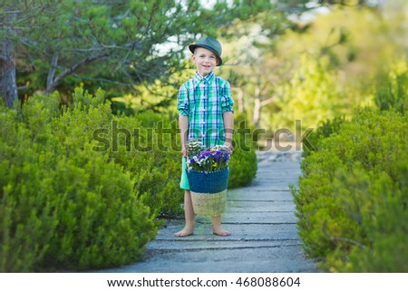 Smiling boy standing with a basket of flowers in green scrubs