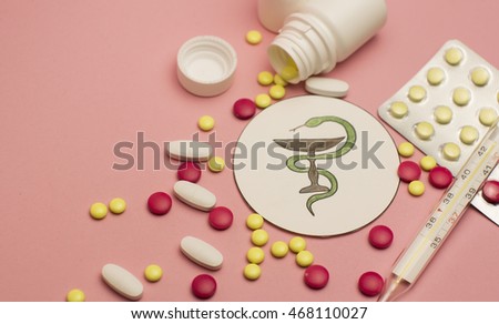 Different pills,medicine bottles on pink background and an illustration of stomach
