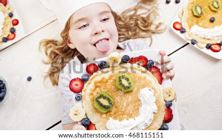 A cute girl surrounded by artistic pancakes