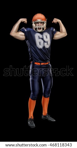 Proud american football player in blue uniform illuminated by floodlights
