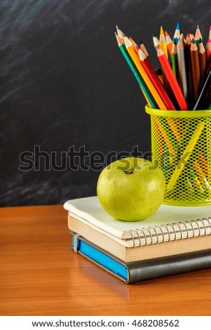 notebook and a container of pencils on the table