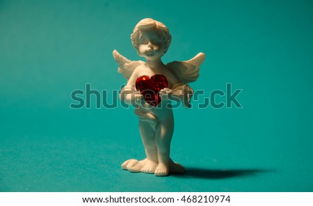  angel decorative figurine near red heart