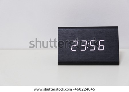 Black digital clock on a white background showing time 23:56 (twenty three hours fifty six minutes)