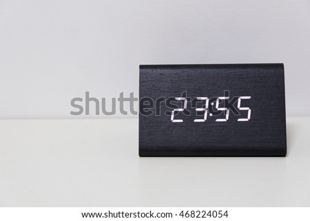 Black digital clock on a white background showing time 23:55 (twenty three hours fifty five minutes)